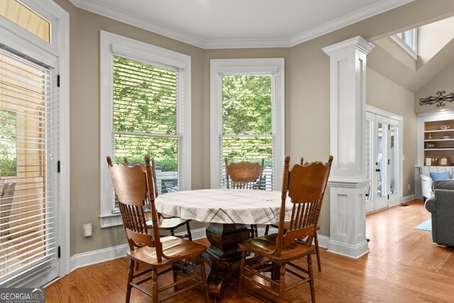 dining space featuring light wood-type flooring, ornamental molding, and a wealth of natural light