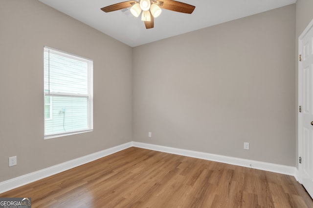 empty room featuring a healthy amount of sunlight, light hardwood / wood-style floors, and ceiling fan