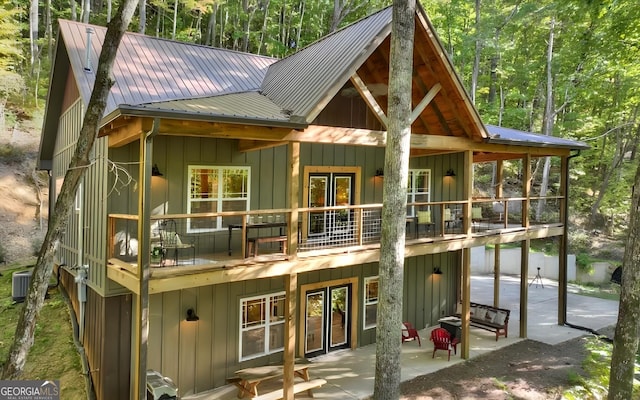 rear view of property featuring central AC, a balcony, and a patio