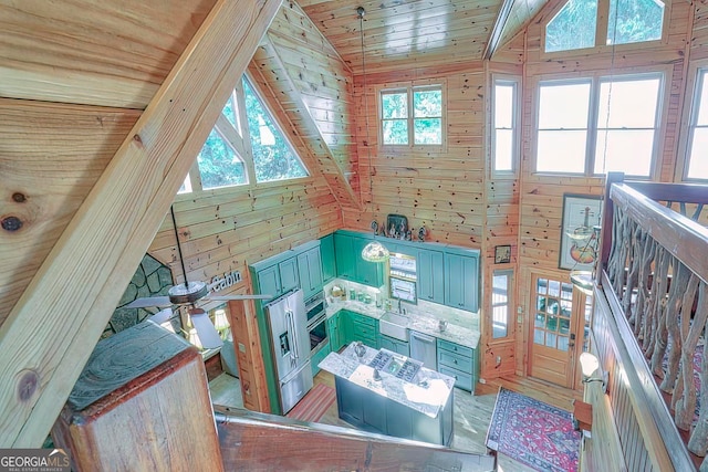 interior space featuring wooden walls, vaulted ceiling, wooden ceiling, and sink