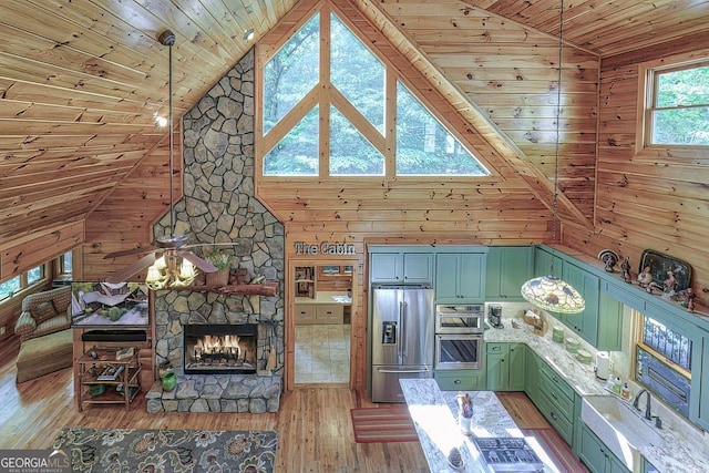 unfurnished living room with wooden walls, a stone fireplace, high vaulted ceiling, light wood-type flooring, and wooden ceiling