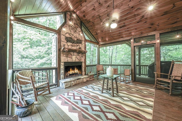 sunroom with lofted ceiling, wooden ceiling, and a fireplace