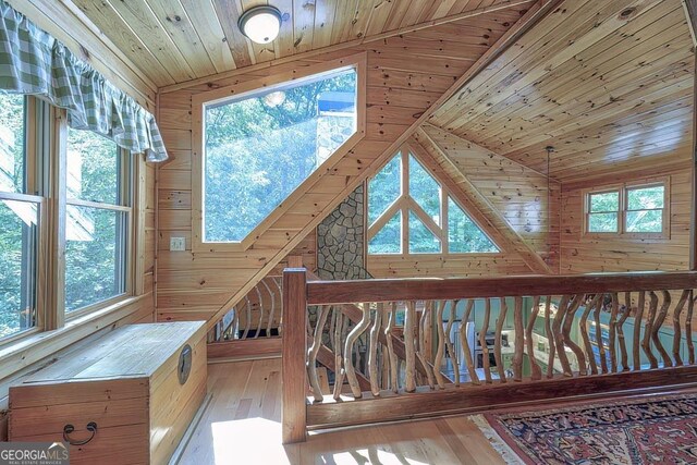 sitting room featuring wood walls, wood ceiling, and light hardwood / wood-style floors