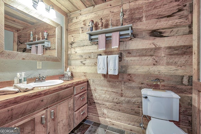 half bathroom with toilet, wood walls, wooden ceiling, and vanity