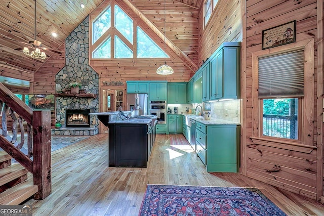 kitchen featuring wood walls, light hardwood / wood-style floors, a healthy amount of sunlight, and high vaulted ceiling