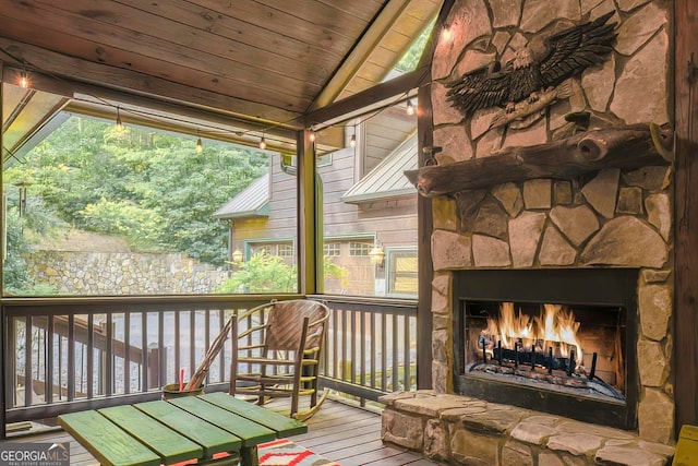 wooden deck featuring an outdoor stone fireplace