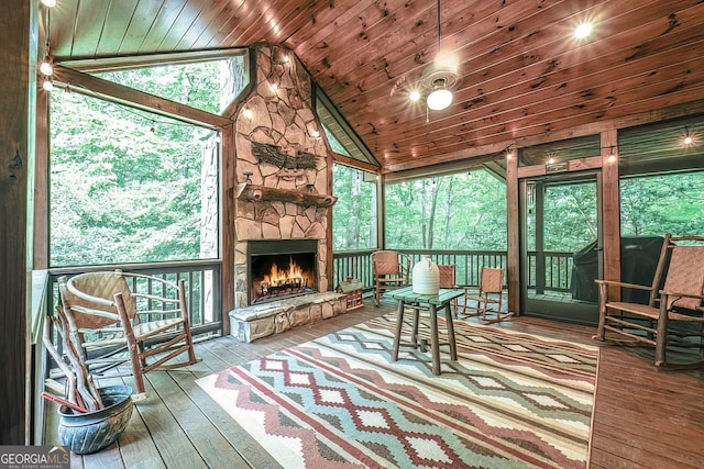 sunroom featuring a fireplace, vaulted ceiling, and wood ceiling