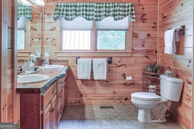 bathroom featuring wood walls, vanity, and toilet