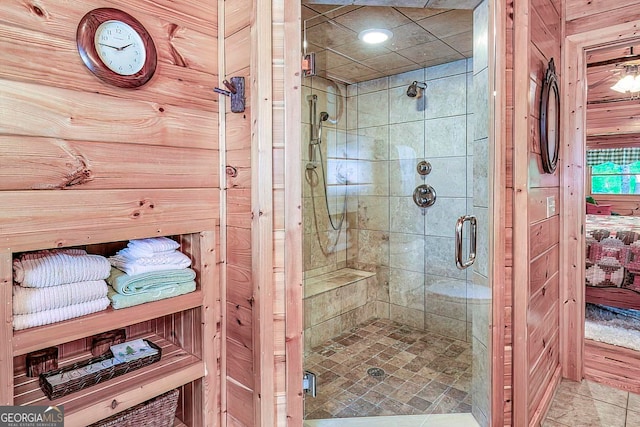 bathroom featuring wooden walls and a shower with door