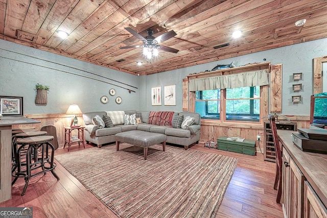 living room with wooden ceiling, light hardwood / wood-style floors, and wood walls