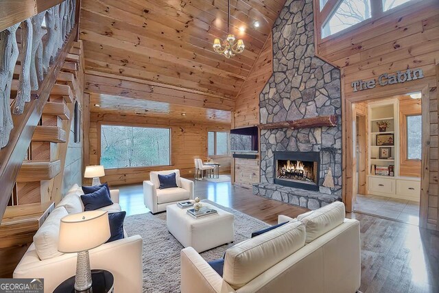 living room with wood walls, wood ceiling, light hardwood / wood-style flooring, and high vaulted ceiling