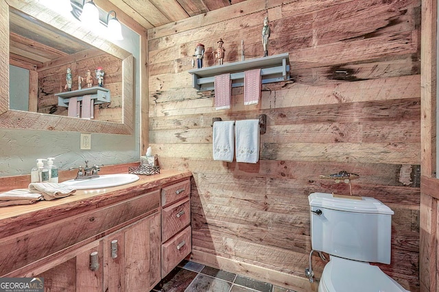 bathroom featuring vanity, wooden walls, toilet, and wood ceiling