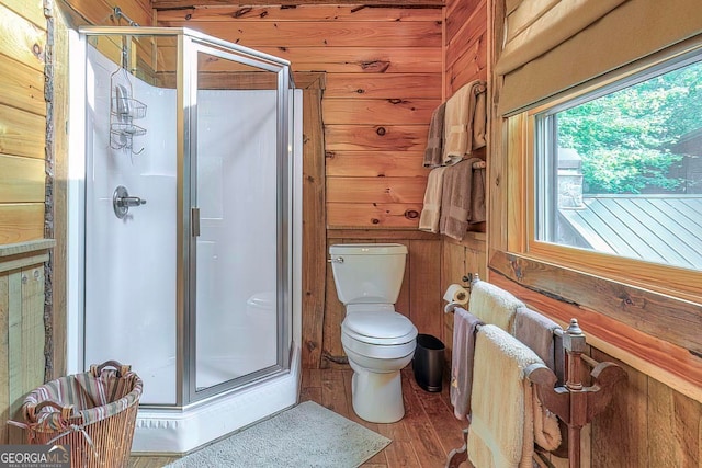 bathroom with toilet, wood walls, hardwood / wood-style flooring, and a shower with door