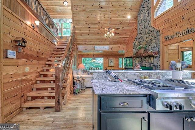 kitchen featuring wood walls, wooden ceiling, light hardwood / wood-style flooring, and high vaulted ceiling