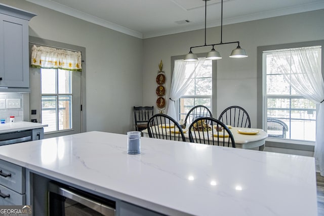 kitchen with decorative light fixtures, crown molding, a wealth of natural light, and gray cabinetry