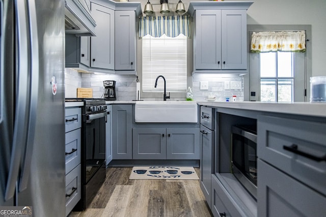 kitchen featuring dark hardwood / wood-style floors, gray cabinets, sink, and appliances with stainless steel finishes