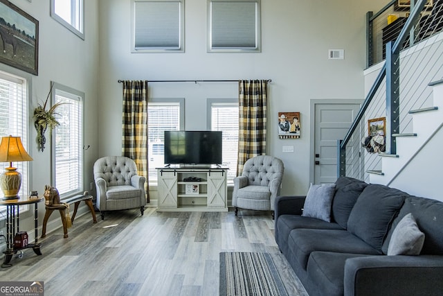 living room featuring wood-type flooring and a high ceiling