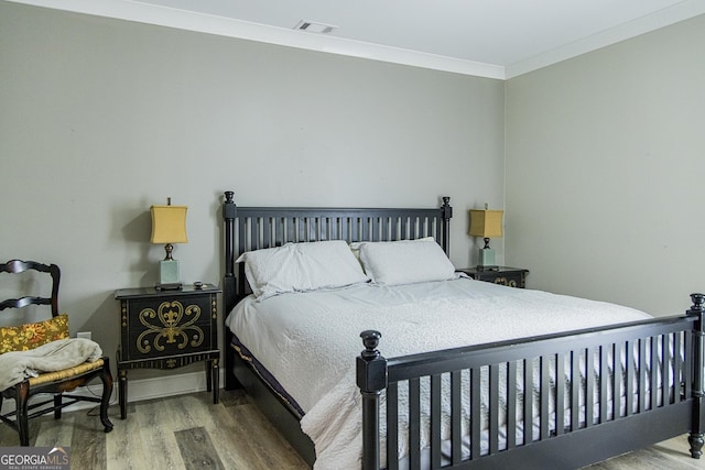 bedroom featuring wood-type flooring and ornamental molding