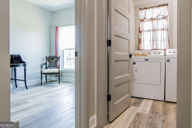 washroom featuring washing machine and dryer and light hardwood / wood-style flooring