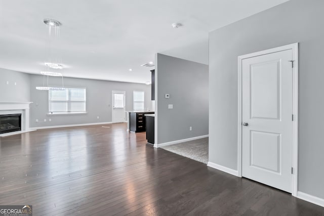 unfurnished living room featuring a fireplace and dark hardwood / wood-style floors