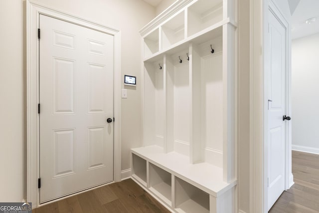 mudroom with dark wood-style flooring and baseboards