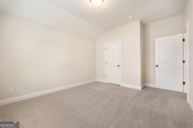 unfurnished bedroom with lofted ceiling, carpet, and baseboards