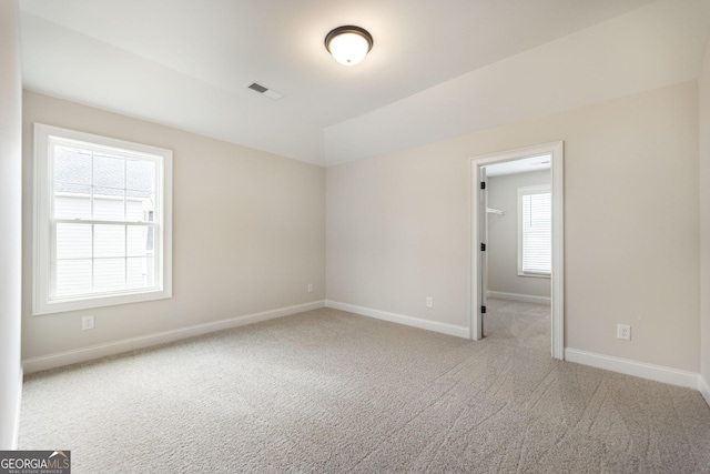 spare room featuring baseboards, visible vents, and carpet flooring