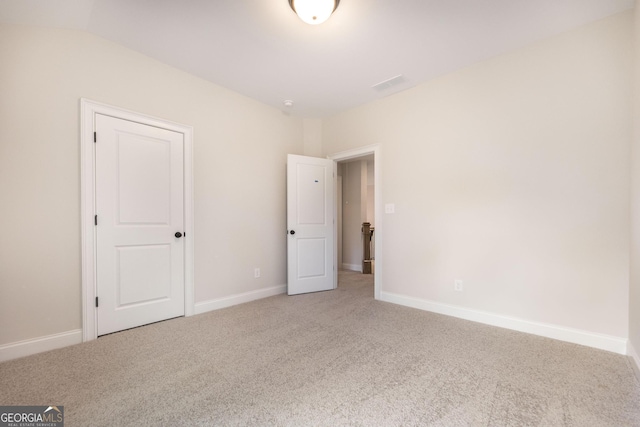 unfurnished bedroom with light carpet, visible vents, and baseboards