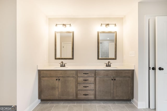 full bath featuring a sink, baseboards, and double vanity