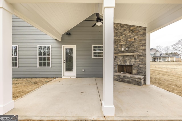 view of patio featuring a ceiling fan and an outdoor stone fireplace