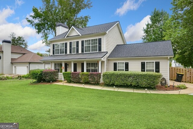 view of front of house featuring a porch, a garage, and a front yard