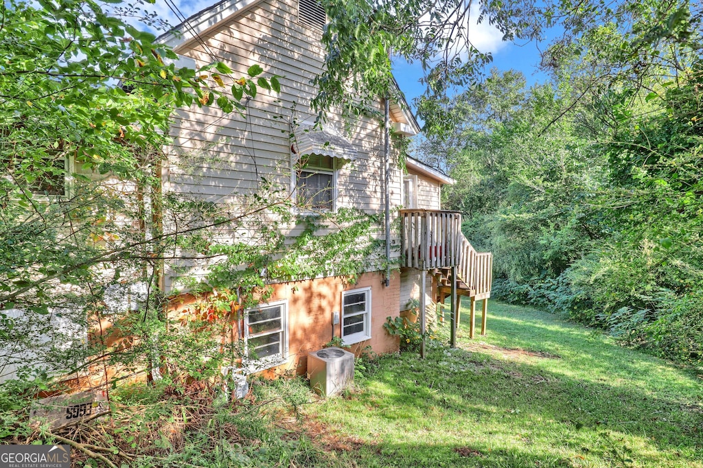 view of home's exterior featuring stairway and a lawn