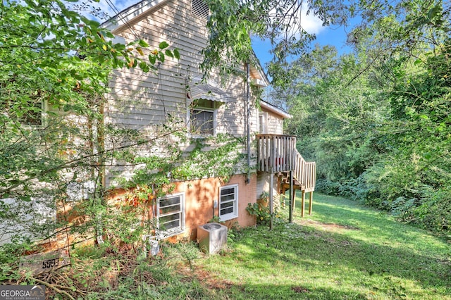 view of home's exterior featuring stairway and a lawn