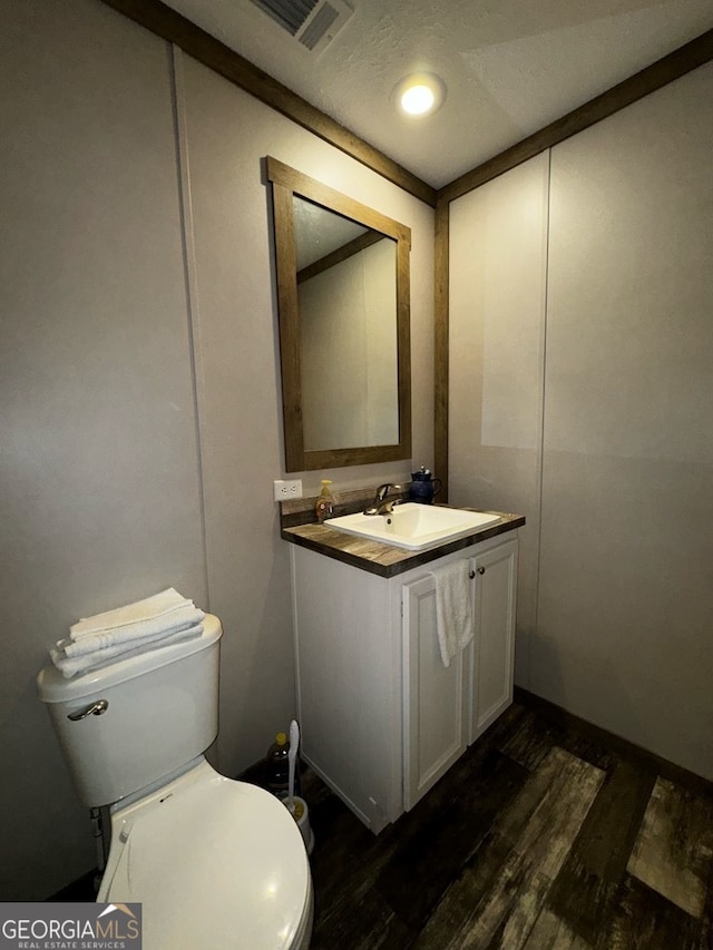 bathroom with hardwood / wood-style floors, vanity, and toilet