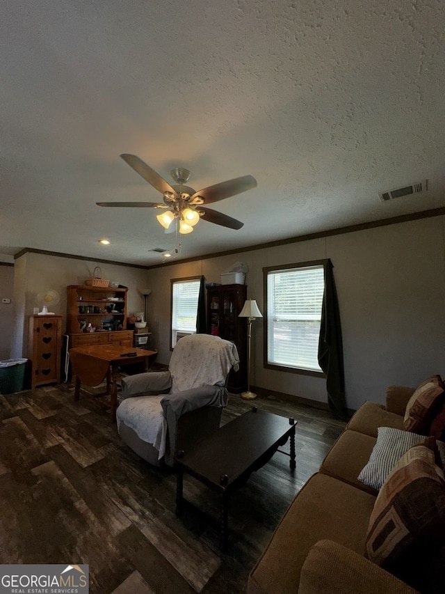 living room with a textured ceiling, dark hardwood / wood-style floors, ceiling fan, and a wealth of natural light