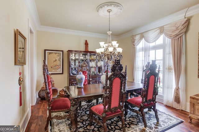 dining area with ornamental molding, a chandelier, and dark hardwood / wood-style flooring