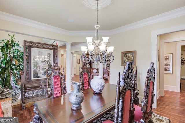 dining space featuring ornamental molding, decorative columns, hardwood / wood-style flooring, and a notable chandelier