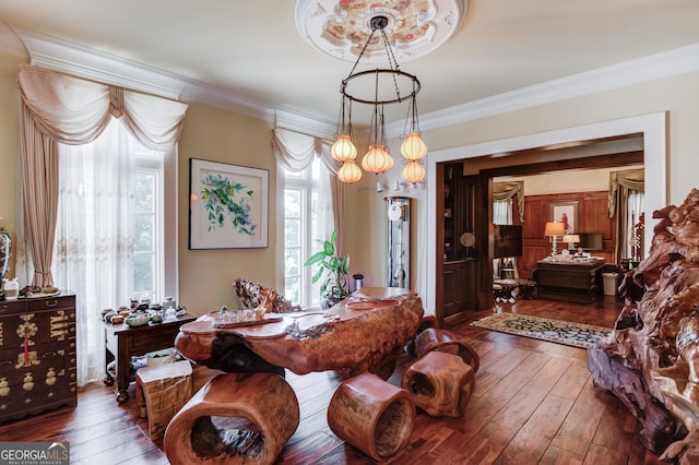 dining space with ornamental molding and dark wood-type flooring