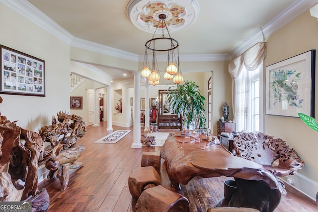 living room featuring ornamental molding, decorative columns, and hardwood / wood-style flooring