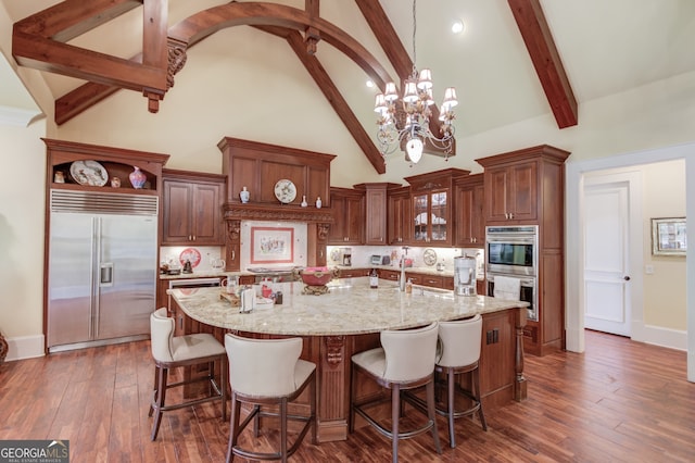 kitchen featuring decorative light fixtures, dark wood-type flooring, a chandelier, high vaulted ceiling, and appliances with stainless steel finishes