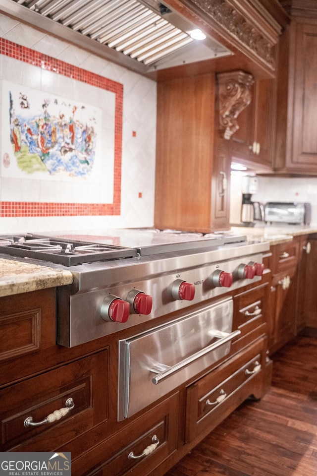 kitchen with tasteful backsplash, stainless steel gas cooktop, wall chimney exhaust hood, dark hardwood / wood-style floors, and light stone countertops