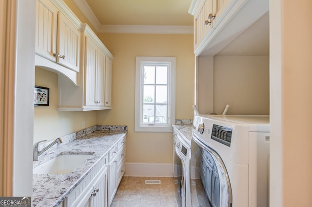 washroom featuring light tile patterned floors, sink, ornamental molding, washer and clothes dryer, and cabinets