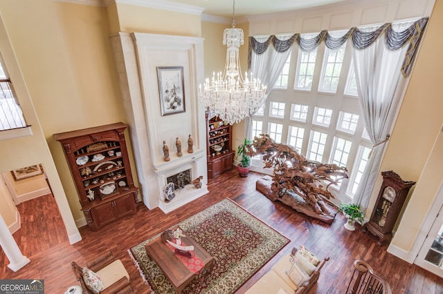 living room with crown molding, dark hardwood / wood-style flooring, and a chandelier