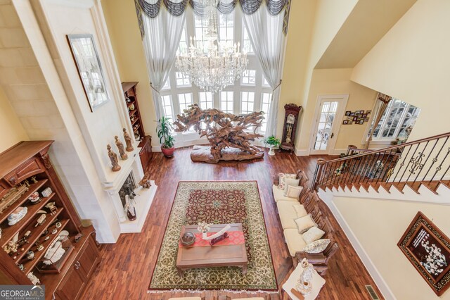 entrance foyer featuring a towering ceiling, an inviting chandelier, and dark wood-type flooring