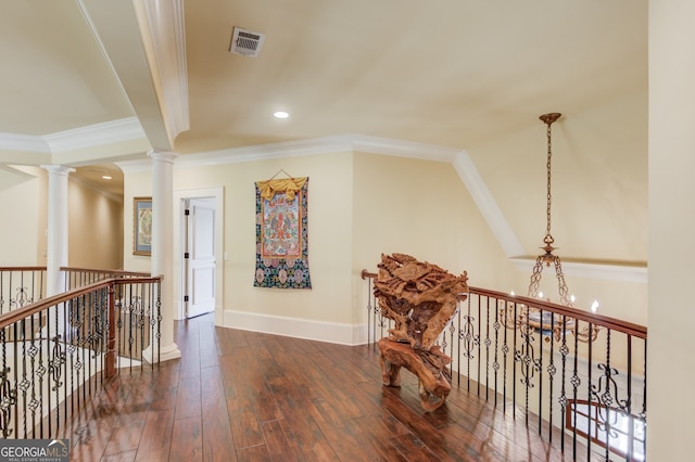 corridor with beamed ceiling, ornamental molding, dark wood-type flooring, a notable chandelier, and ornate columns