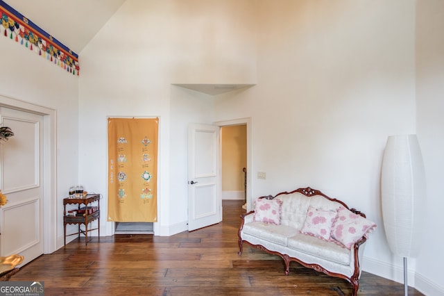 sitting room with dark hardwood / wood-style floors and high vaulted ceiling