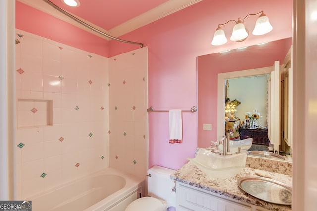 full bathroom featuring vanity, crown molding, tiled shower / bath, and toilet