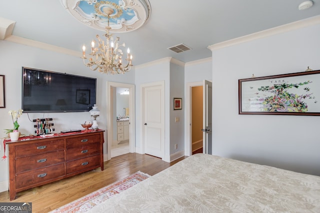 bedroom featuring a notable chandelier, ensuite bath, light hardwood / wood-style floors, and crown molding