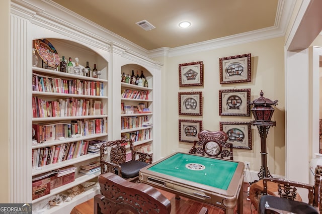 rec room featuring crown molding, built in shelves, and hardwood / wood-style flooring