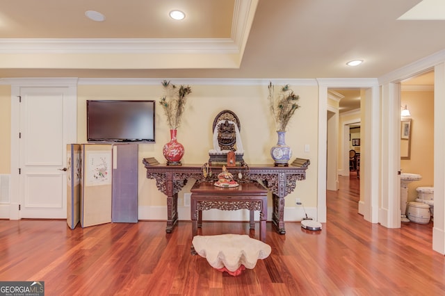 misc room featuring wood-type flooring and crown molding